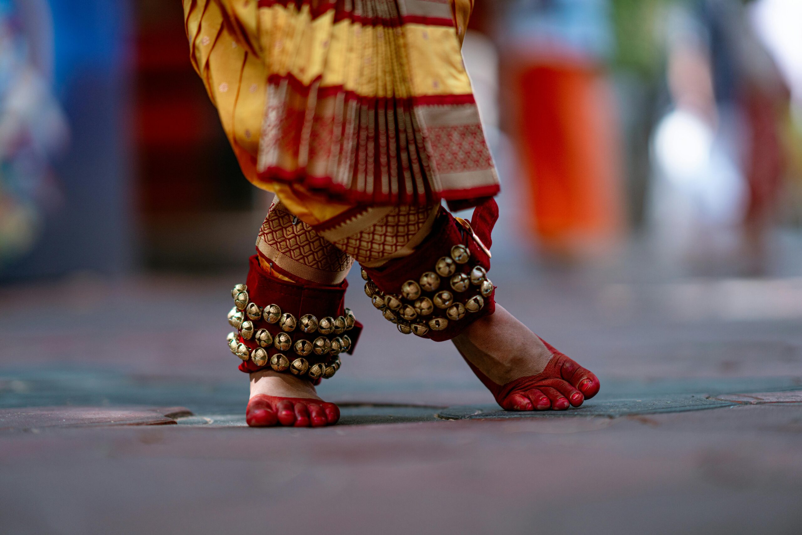Close-up of classical Indian dance footwork in Kerala attire with ghungroo anklets.